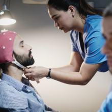 Nurse placing a brain mapping cap on a patient