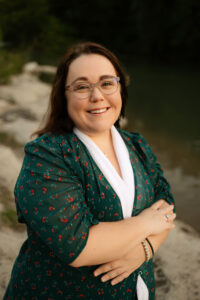 Caucasian female wearing green shirt and glasses.