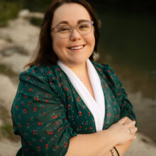 Caucasian female wearing green shirt and glasses.