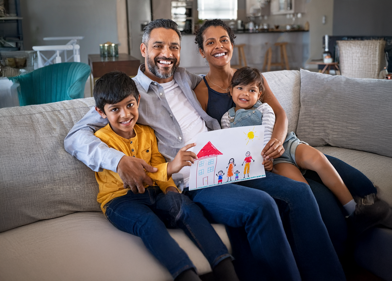 An image of a smiling family on a couch