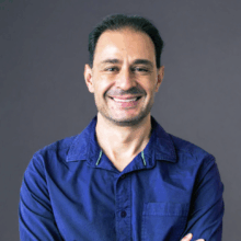 23a25211-3083-4d39-b79d-666f1d57cdaa smiling man in blue shirt with crossed arms